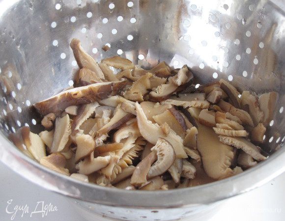 Через 20 минут слить жидкость и слегка отварить грибы, минут 5-7. Откинуть на дуршлаг, остудить. Если использовать свежие грибы шиитаке или шампиньоны, то эти операции можно опустить.