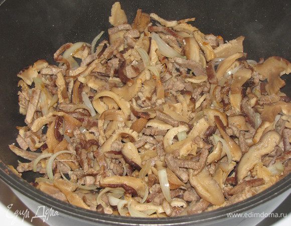 Отваренные грибы отжать и добавить к мясу. Если нужно, добавить еще кунжутное масло. Все перемешать и жарить минуты 3.