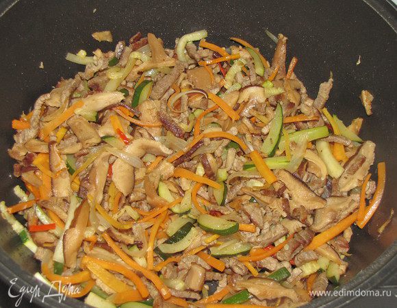 Ранее нарезанные морковь и цукини соединить с мясом и грибами, добавить сухой имбирь, мелко нарезанный зеленый  острый перец, посолить.  Все  хорошо перемешать и быстро обжарить при постоянном помешивании. Овощи не должны стать мягкими, они должны остаться слегка хрустящими и сочными. В конце жарки добавить рисовый уксус, перемешать. Снять с огня, накрыть крышкой.