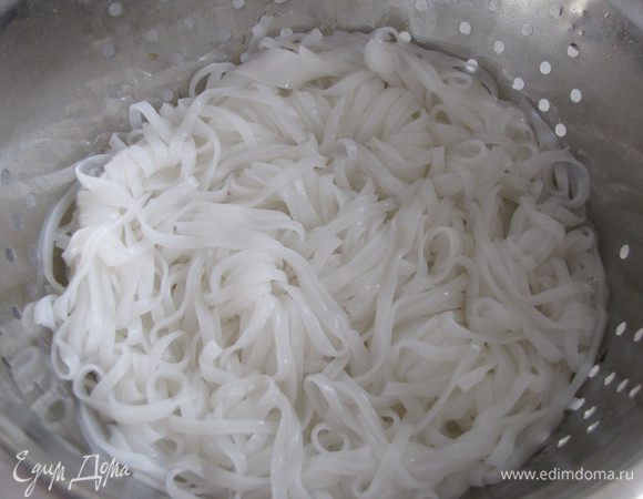 Рисовую лапшу отварить, как написано на упаковке. Отбросить на дуршлаг, промыть холодной водой.