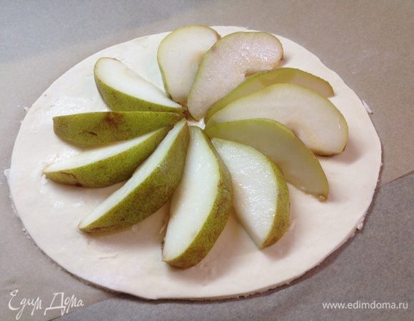 Грушу нарезаем и выкладывает на тесто. 