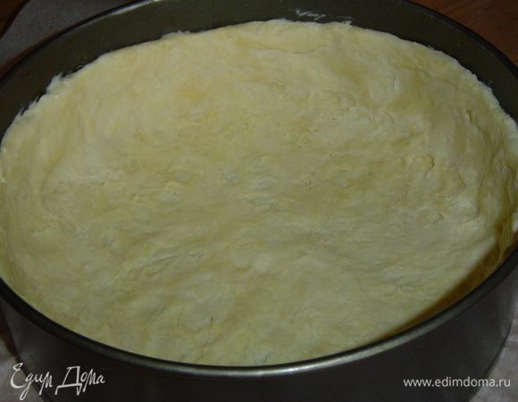Берем форму (у меня в диаметре 26см), дно застилаем пергаментом, сверху кладем тесто и распределяем его по дну и бокам формы, а затем форму с тестом отправляем в холодильник.