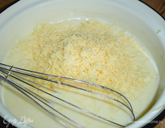 Овощи уложили на тесто и теперь осталось приготовить заливку. Слегка взбиваем яйца венчиком, добавляем молоко и еще раз взбиваем, затем кладем измельченный чеснок, натертый на мелкой терке сыр, солим по вкусу, и все тщательно перемешиваем.
