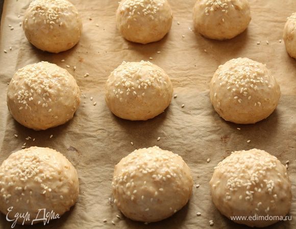 Противень покройте пекарской бумагой и уложите на него булочки. Намажьте булочки  взбитым яйцом. Сверху посыпьте кунжутом.
Поставьте противень в разогретую до 180-200 градусов духовку для выпечки на 30-35 минут. 