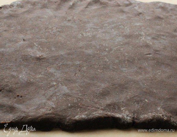 Выложить тесто на выстеленную пергаментом поверхность и раскатать пласт размером примерно 25 / 30 см.