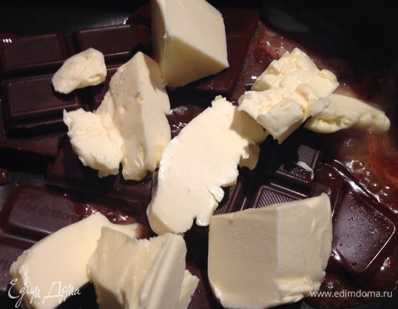 К нему же добавляем кусочки масла и иногда перемешиваем, пока не образуется однородная масса (жидкий шоколад) и снимаем с огня.
