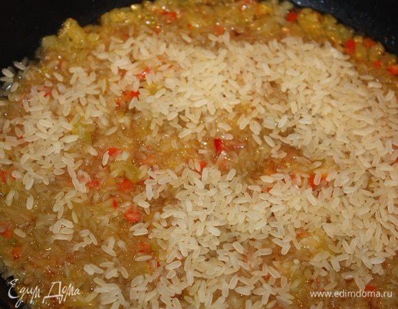 Добавляем рис,  даем ему прогреться и впитать все ароматы. Через 5-7 минут добавить воду и посолить.