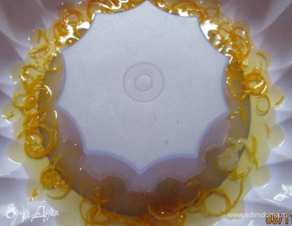 С оставшегося апельсина снимаем цедру, лучше использовать приспособление для нарезки полосочек. 
На дно формы выкладываем цедру, вливаем половник желе и убираем в холодильник на 15 мин.