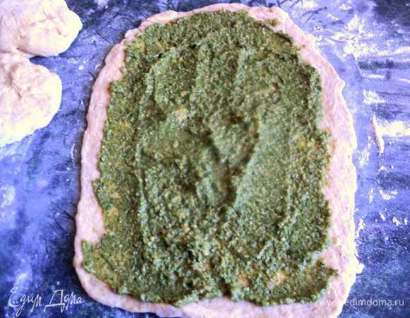 Тесто разделить на три части. Раскатать тесто в пласт толщиной 5 мм и смазать начинкой.