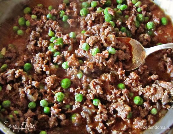 К обжаренному фаршу добавить томатный соус и горошек. Готовить ещё 10 мин.