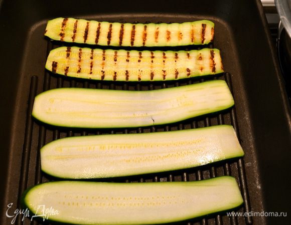 Для приготовления этого блюда лучше всего подобрать достаточно длинные и ровные кабачки, тогда нарезанные полосочки цукини будут достаточной длины. Нарезанные цукини пожарить на сковороде гриль. 
