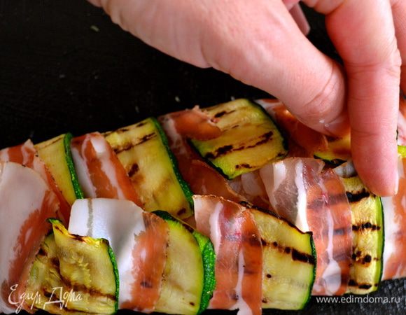 Затем берем грудку обеими руками и переворачиваем так, чтобы закрыть ее с другой стороны полосочками бекона и цукини. 