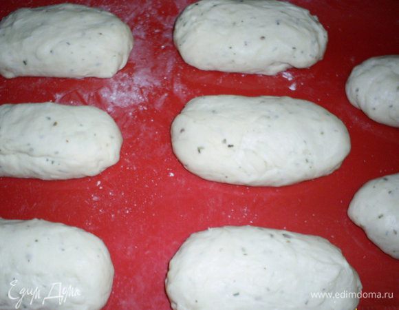 Выкладываем тесто на стол, обминаем, даем отдохнуть 5 минут, затем делим на 8 равных частей. Из каждой формируем маленький продолговатый батончик, выкладываем на противень с пергаментом или ковриком для выпечки и оставляем на 20 минут.