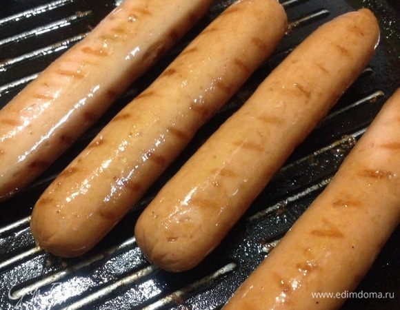 Сосиски выкладываем на горячую гриль сковороду обжариваем со всех сторон. Затем нарезаем вдоль по диагонали и начинаем сервировать. 