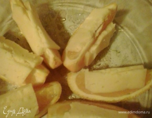 На каждую дольку апельсина кладем по кусочку сыра и отправляем в разогретую духовку на 10-15 минут, ждем пока сыр  расплавиться. Перед подачей посыпаем тертым шоколадом и измельченным миндалем. Приятного аппетита!!!