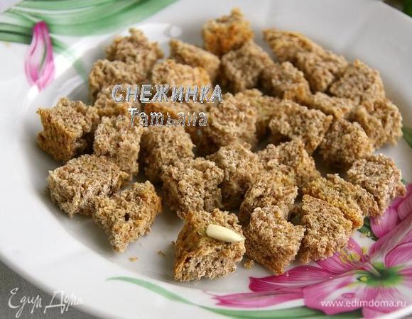 Кладём их на противень. Духовку разогреваем до 250С. Выключаем и ставим противень с хлебом. Когда духовка остынет, достаём сухарики, перекладываем на тарелку и слегка натираем чесноком.