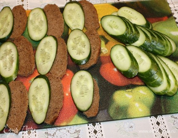 Хлеб и огурцы порезать одинаковой формы. Яйца сварить, почистить и разрезать на четыре части.