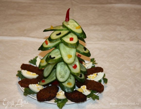 Нанизывать огурцы в виде елочки. Верхушку елочки можно сделать из чили перчика. Выкладываем гренки и яйца.