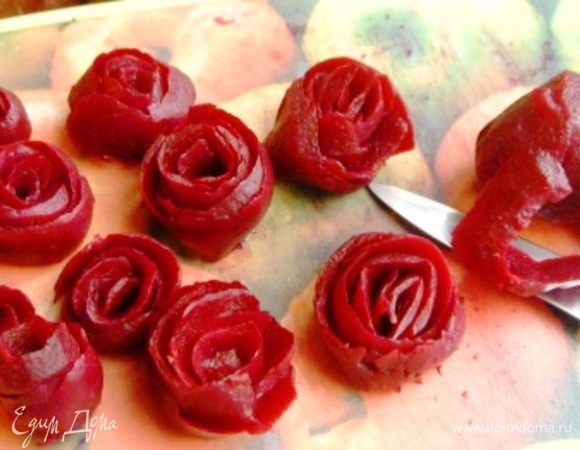 Из вареной свеклы вырезать розочки. Поверьте, даже если вы не обладаете талантом карвингиста (как, например, я) – у вас все равно получатся симпатичные розочки разной степени раскрытия.  Для этого нужно снимать ножом длинный слой по кругу, как будто чистите картошку.  Затем эту стружку свернуть  в трубочку - получится розочка.