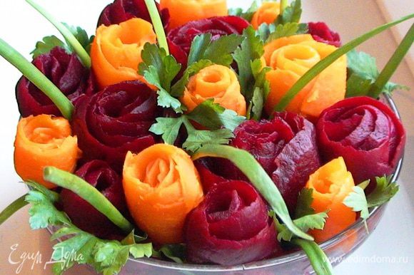 Украсить салат розами из свеклы и моркови, листьями петрушки и перьями зеленого лука.