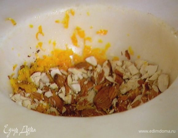 Миндаль и цедру апельсина добавить в ступку к специям и все измельчить так, чтобы остались маленькие кусочки миндаля.