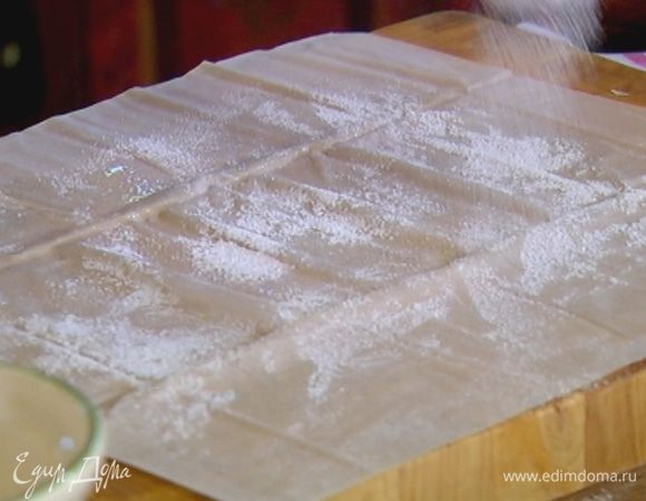 Три листа фило уложить один на другой, промазывая каждый оливковым маслом и слегка присыпая сахарной пудрой, сверху накрыть последним листом фило.