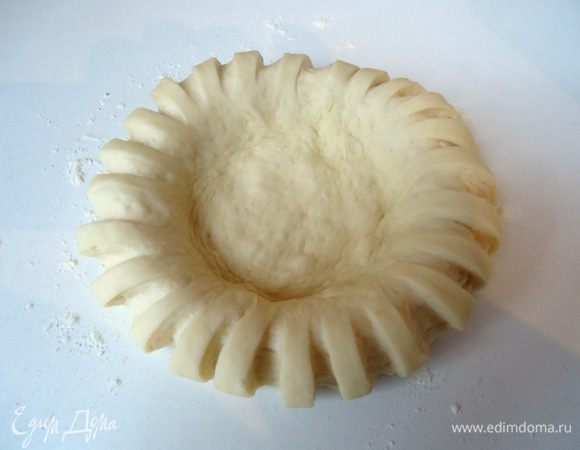 Положить на рабочую поверхность и кулачком придавить  центр лепешки, тем самым увеличивая её диаметр.
