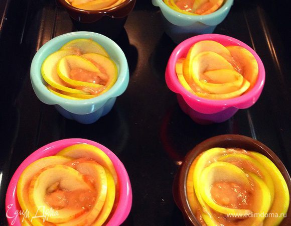 Выкладываем смесь в формы для кексов, заполнив на 2/3.....украшаем кексы кусочками яблок, выгибая их полукругом, как лепестки роз.