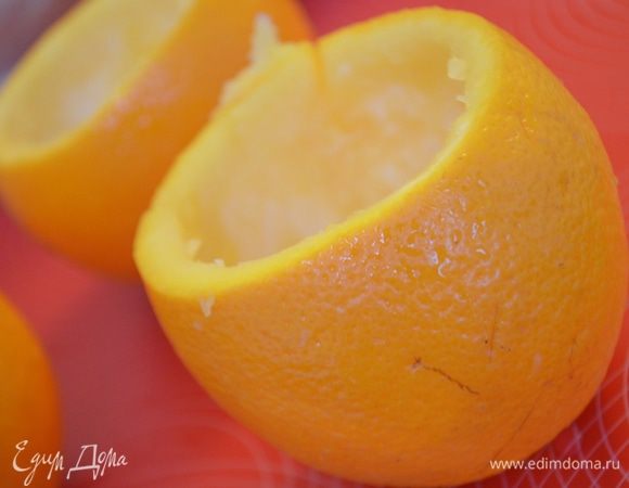 У апельсинов срезать верхушки. Мякоть убрать большой ложкой так, чтобы не повредить кожуру. 
