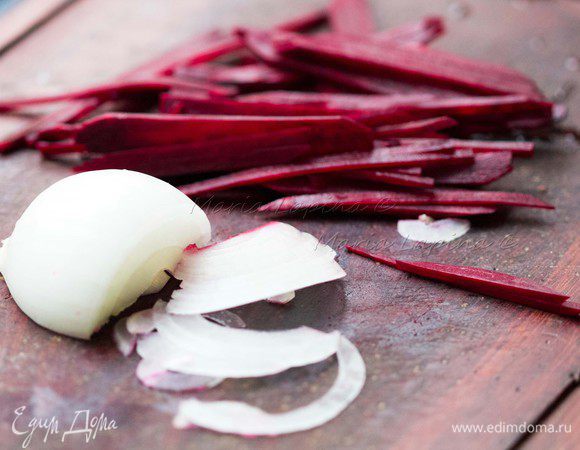 Свеклу почистить и нарезать на тонкие длинные полоски. Лук нашинковать полукольцами.