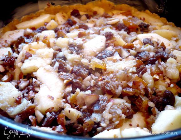 Раскатаем больший кусочек теста, слегка присыпав его мукой сверху, по диаметру формы на припыленной мукой поверхности. Выложим в смазанную маслом форму, образуя небольшие бортики. Сверху распределим начинку.