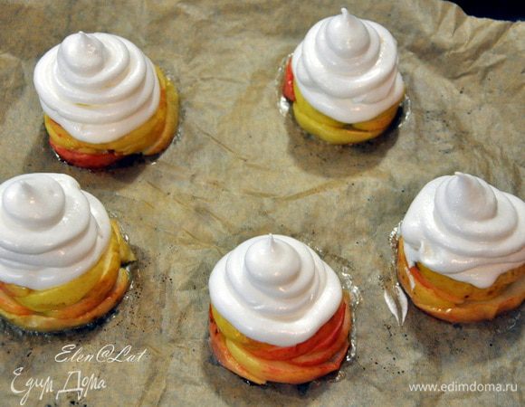 В это время взбиваем белки с несколькими капельками лимонного сока до мягких пиков. Дождиком подсыпаем сахар и взбиваем до состояния меренги. С помощью кондитерского мешка отсаживаем на яблочки меренгу и отправляем пирожные обратно в духовку. Но перед тем, как отправить температуру в духовке снижаем до 150С. Выпекаем наши пирожные еще 5-7 минут. 