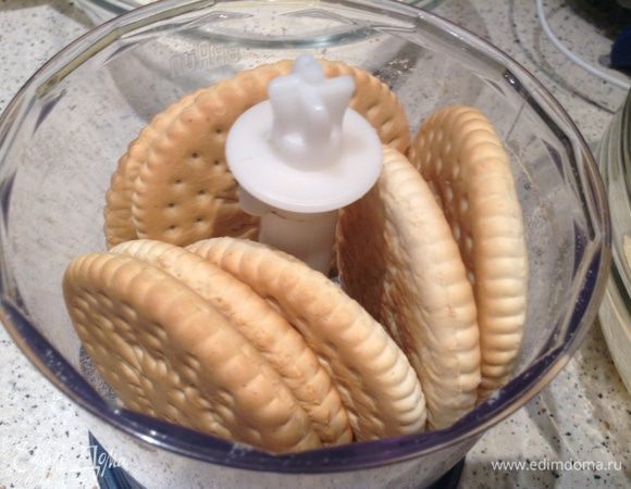 Измельчить печенье и смешать с 100 г растопленного масла.