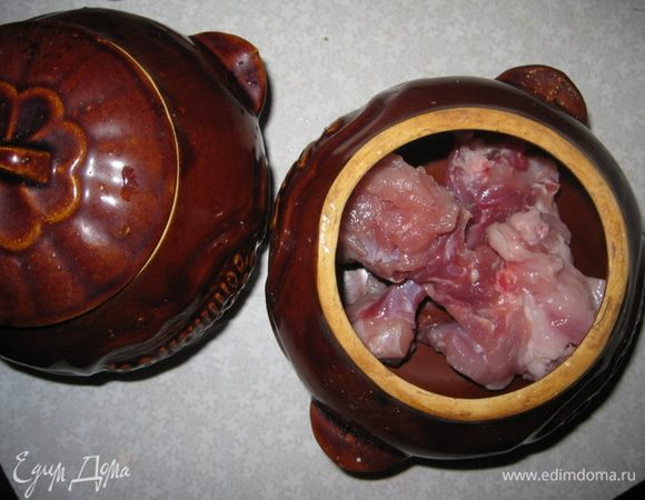 В горшочек на дно кладем кусочки кролика. Солим.