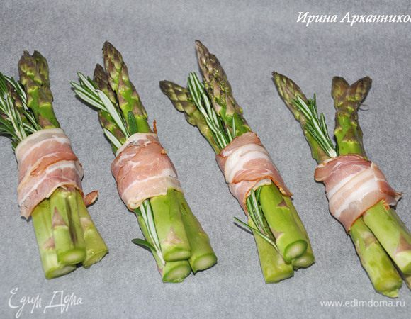   Сложить вместе 3 штучки спаржи, ветку розмарина и обернуть 3 полосками бекона. Выложить на противень, устланный пергаментом.