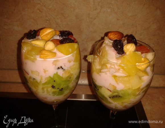 Десерт для взрослых - в фужере фрукты слоями, добавьте йогурт, орешки и изюм.