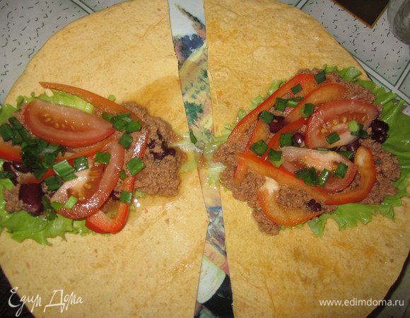 На лепешки положить по салатному листу. Сверху разместить начинку из фарша и фасоли и нарезанные овощи. Посыпать  зеленым луком. Свернуть лепешки в трубочки. По желанию буррито можно посыпать тертым сыром (любого сорта) и запечь в разогретой духовке 220 С минут 15, мне в горячем виде это блюдо понравилось больше!