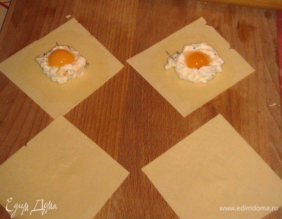 Из теста накатываем тонкие (1 мм толщиной пласты). С помощью формы вырезаем квадраты (у меня 4*4 см). На центр столовую ложку начинки, делаем аккуратное углубление. Кладем желток (напоминаю, перепелиное яйцо). Закрываем таким же квадратом.