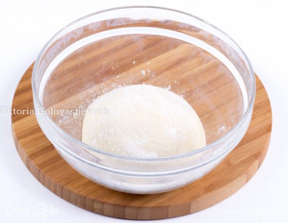 Разогреть духовку до 250 ° C. Натрите дрожжи с мукой с помощью кончиков пальцев, получатся крошки. Добавить оливковое масло и воду, и замесить тесто, чтоб оно собрало всю муку. Теперь выкладываем наше липкое тесто на стол и начинаем месить. 
Основная цель – это насытить его как можно больше кислородом. Для этого берем тесто и растягиваем в разные стороны. Затем делаем большой взмах руками сначала от себя, а потом вместе с тестом к себе, захватывая воздух, и складываем тесто пополам.Потом еще раз в стороны, и вверх, вытягивая тесто.
И так нужно проделывать до тех пор, пока тесто не станет полностью отлипать от поверхности и не станет гладким и упругим. После этого выложить тесто на присыпанную мукой поверхность и сформировать из него шар. Для этого необходимо брать за края и заворачивать их во внутрь, к центру. Потом шар необходимо перевернуть и подоткнуть края.
У Вас должен получиться очень нежный и шёлковый колобок. 
