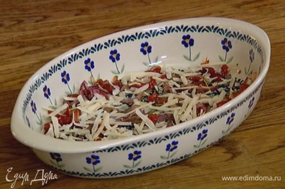 В жаропрочную керамическую форму выложить помидоры с луком и тимьяном, посыпать половиной натертого сыра.