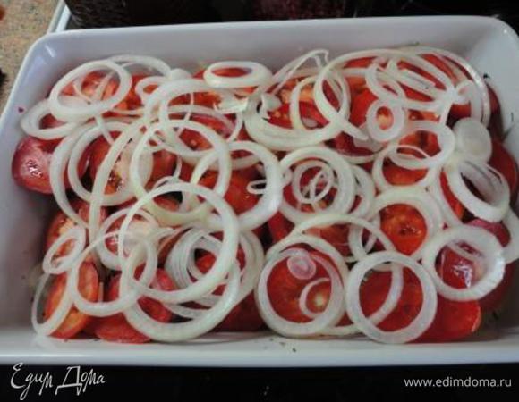 Кружочки помидоров выложите на рыбу, сверху — оставшиеся колечки лука, немного соли и перца.