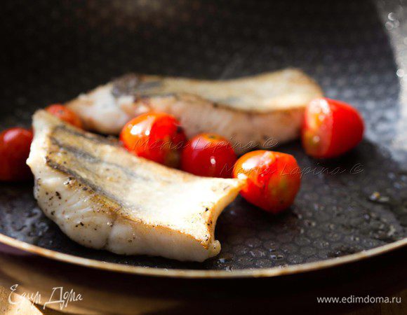 Филе судака разрезаем на порционные кусочки, солим и перчим. Кладем на раскаленную сковородку с маслом шкуркой вниз. Жарим на большом огне, прижимая рыбу первые 30 секунд лопаткой. Добавляем в сковородку томаты черри, разрезанные на половинки. Рыбу переворачиваем, когда шкурка станет румяной и хрустящей. Жарим на другой стороне ещё 5-7 минут. 