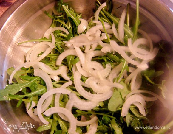 Руколу промыть, обрезать корешки. Лук нарезать полукольцами, добавить к зелени. 