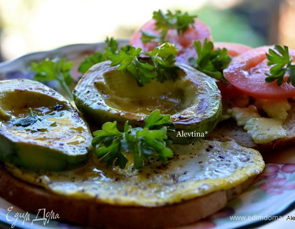Хлеб обжарить в тостере,  смазать мякотью авокадо. На вторую половинку выложить авокадо с яйцом. Подаем с помидорками и зеленью. Приятного аппетита.