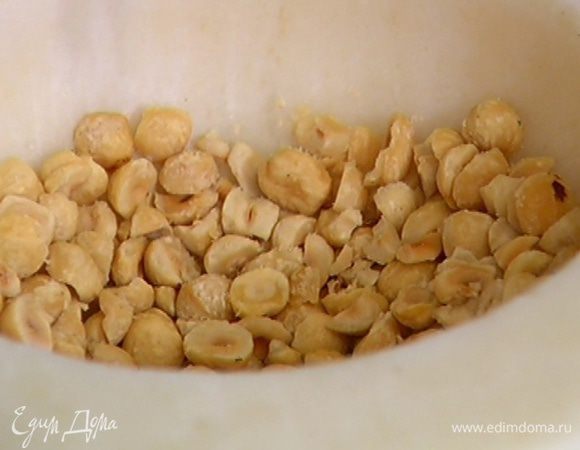 Две горсти орехов измельчить в ступке в крупную крошку.