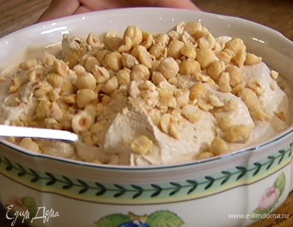 В готовое мороженое добавить измельченные орехи и перемешать. Каждую порцию мороженого украсить оставшимися целыми орехами.