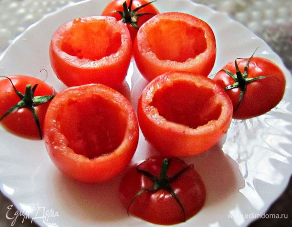 Срезать у помидоров верхушку и вынуть мякоть с семенами.
Посолить и поперчить помидоры изнутри.
