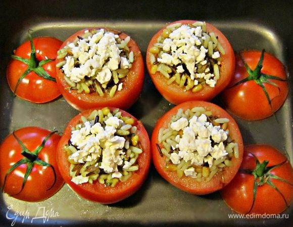 Наполнить начинкой помидоры, сверху посыпать фетой и сбрызнуть оливковым маслом. Поставить фаршированные помидоры в смазанную оливковым маслом форму для запекания. Запекать помидоры в разогретой до 180г духовке  в течение 20мин.