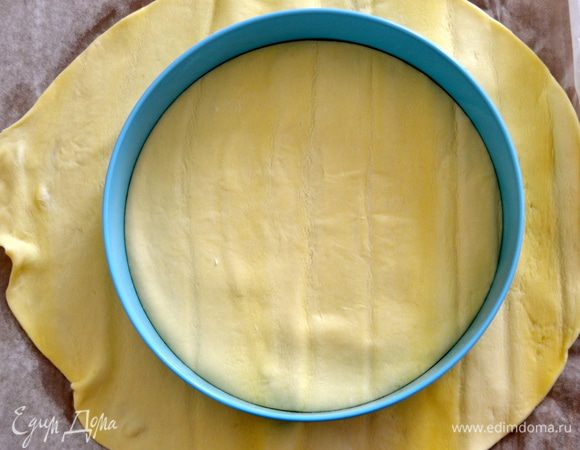 Слоеное тесто раскатать толщиной 2 мм и вырезать из него диск диаметром 20 см (можно использовать форму для выпечки соответствующего размера как трафарет). 