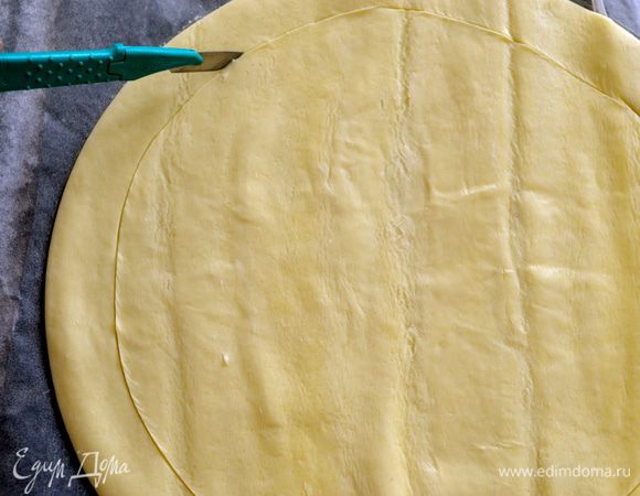 Переложить диск слоеного теста на поднос и сделать неглубокий надзрез по всей кромке круга, отступив от края 1,5-2 см. 